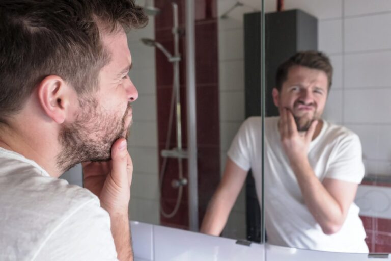 Man check condition of his skin in the mirror and realized the importance of man skin care