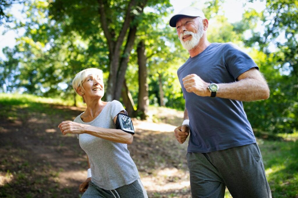 屋外でスポーツをする熟年またはシニアのカップル、公園でのジョギング