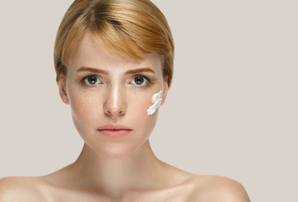 Against dry skin in winter Woman beauty mask cream cosmetics skin care. Cream on cheeks.